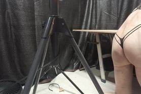 A cross-dressing guy whipping with rubber attached to t