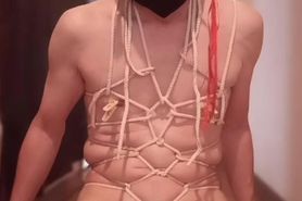 A man wearing a mask binds his body by himself
