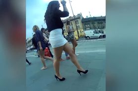 Brunette girl with fabulous legs walks in mini skirt