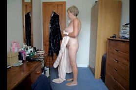 A Granny taking a shower and  putting on her white bra 