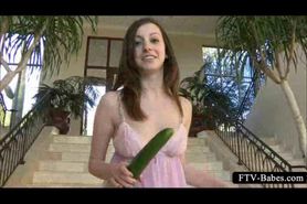 Playful teenie shoving big cucumber in her twat